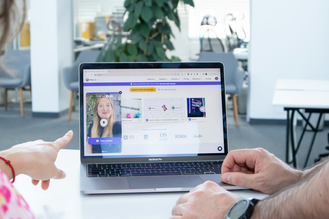 a man and a woman sitting in front of a laptop computer